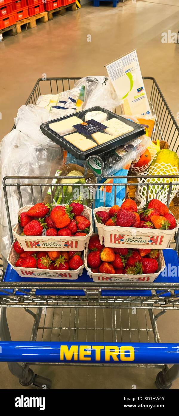 Belin, Germany - May 30, 2025: Grocery cart is filled with fresh strawberries, cheese, and various items in store. Hospital - Smartphone Captured Stock Image
