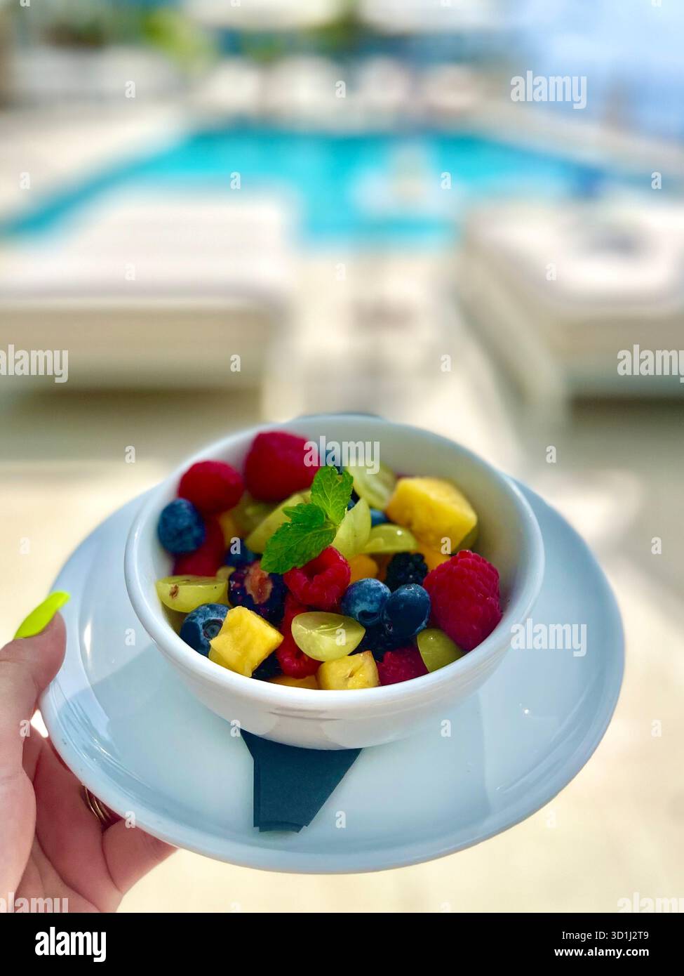 Fresh tropical fruit salad served by a luxury resort pool on a sunny summer day in the Cayman Islands. - Smartphone Captured Stock Image
