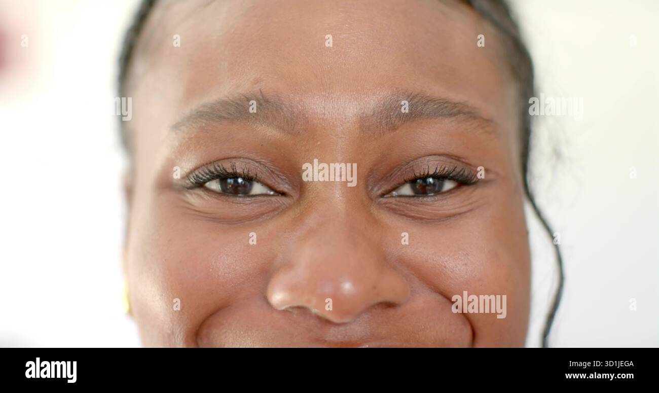Showing close-up adult woman featuring smooth skin and braids in studio with white backdrop Stock Photo