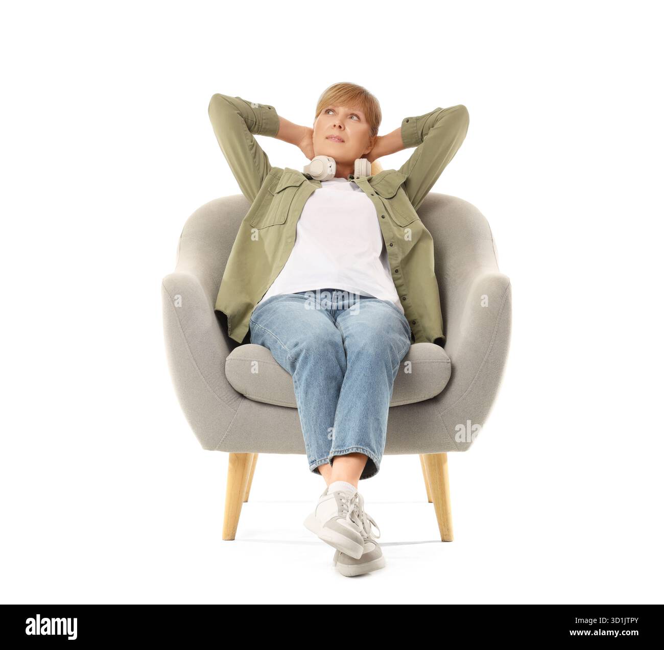 Mature woman sitting in grey armchair on white background Stock Photo ...