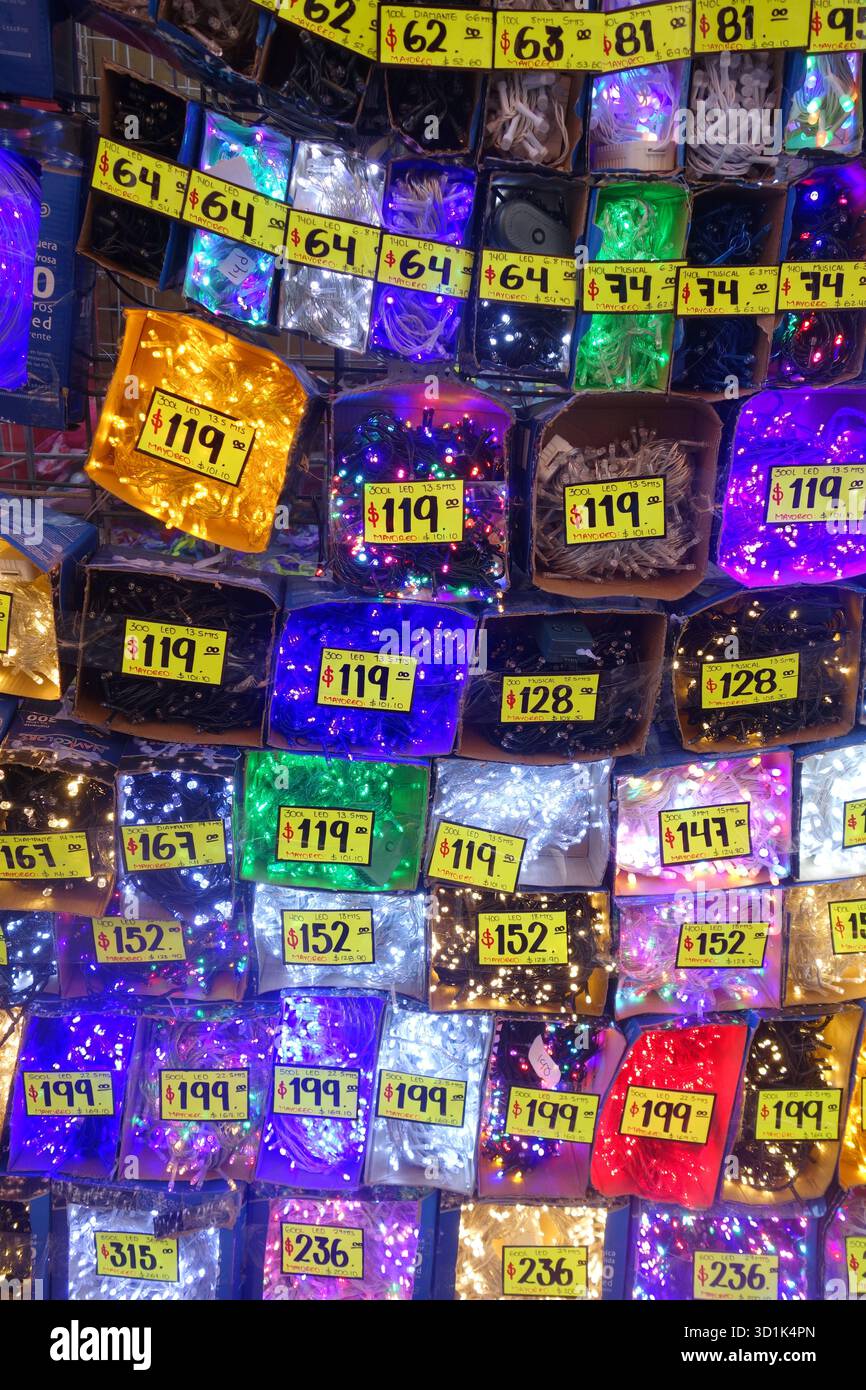 Colorful display of decorative LED string lights for sale with yellow price tags in a market stall Stock Photo
