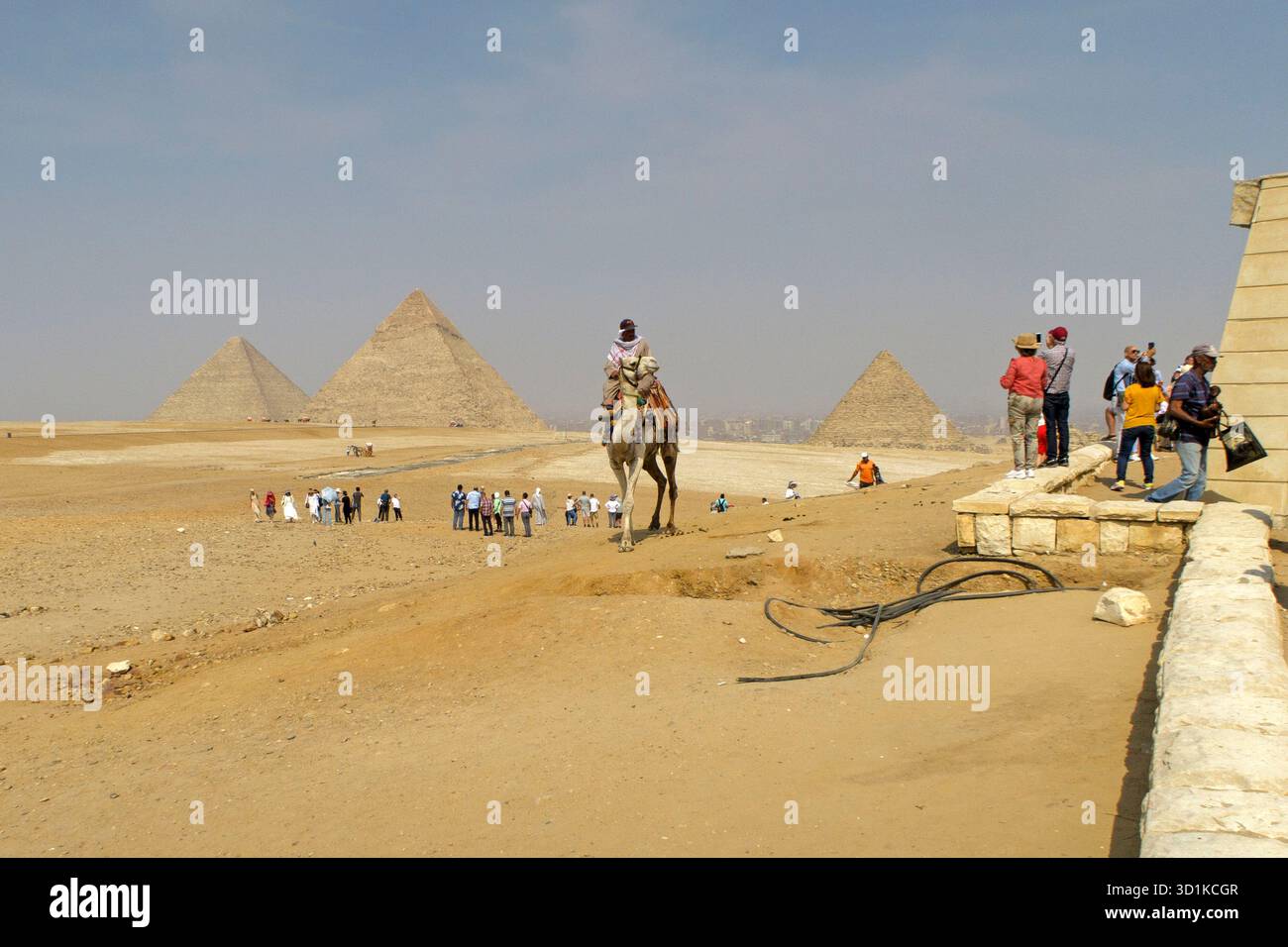 Tourists explore the Giza Plateau with the iconic pyramids in the ...