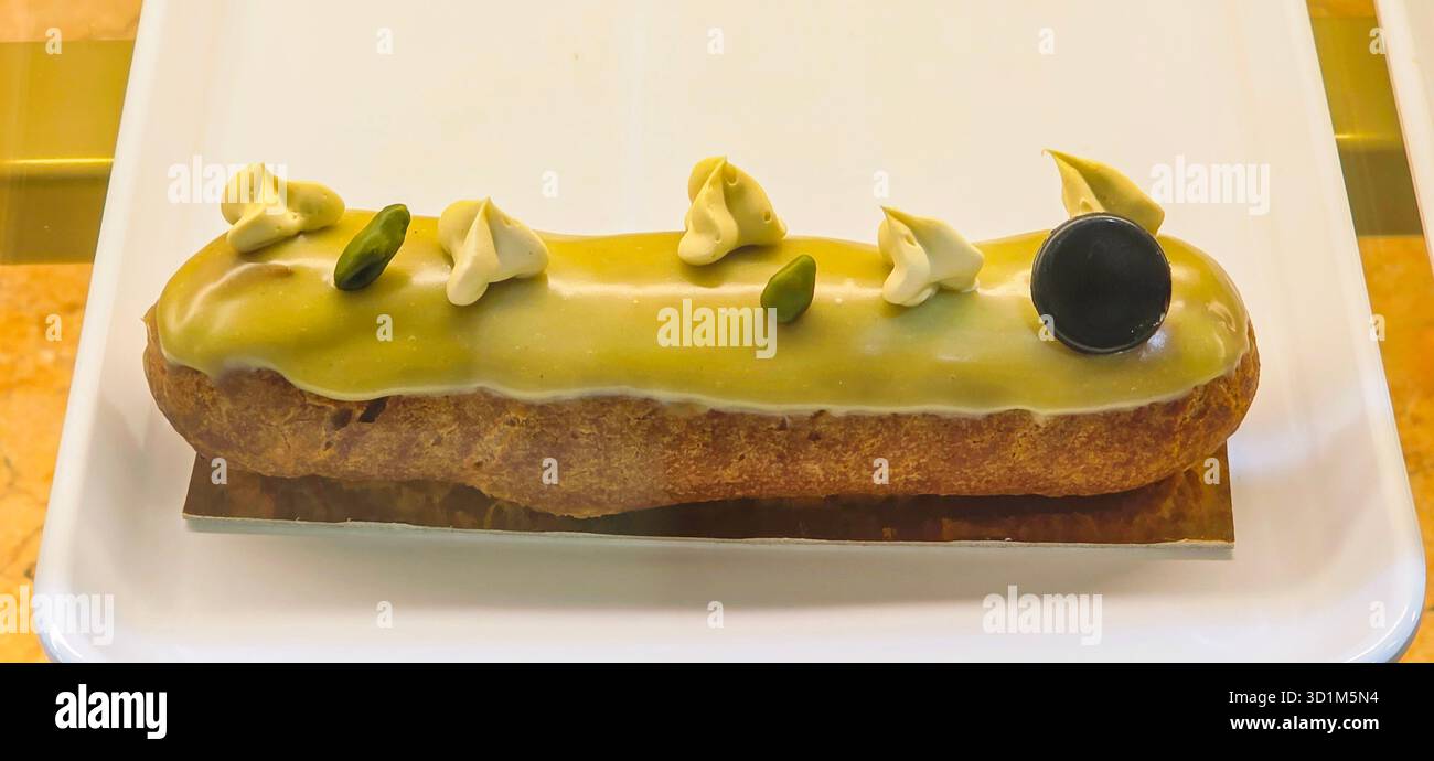 Gourmet pastry features a vibrant green glaze, topped with decorative elements, showcasing culinary artistry and attention to detail. - Smartphone Captured Stock Image