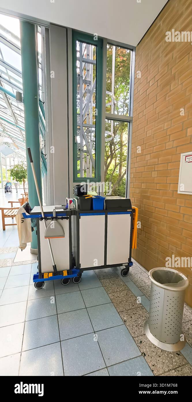 Belin, Germany - May 30, 2025: Cleaning cart equipped with supplies in bright modern building entrance area. Hospital - Smartphone Captured Stock Image