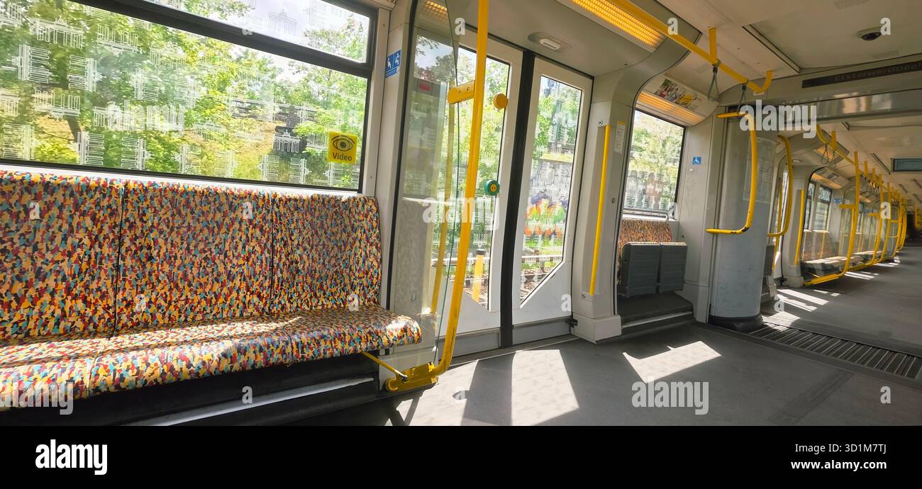 Berlin, Germany - May 22, 2025: Colorful patterned seats are visible in an empty subway train illuminated by natural light. - Smartphone Captured Stock Image