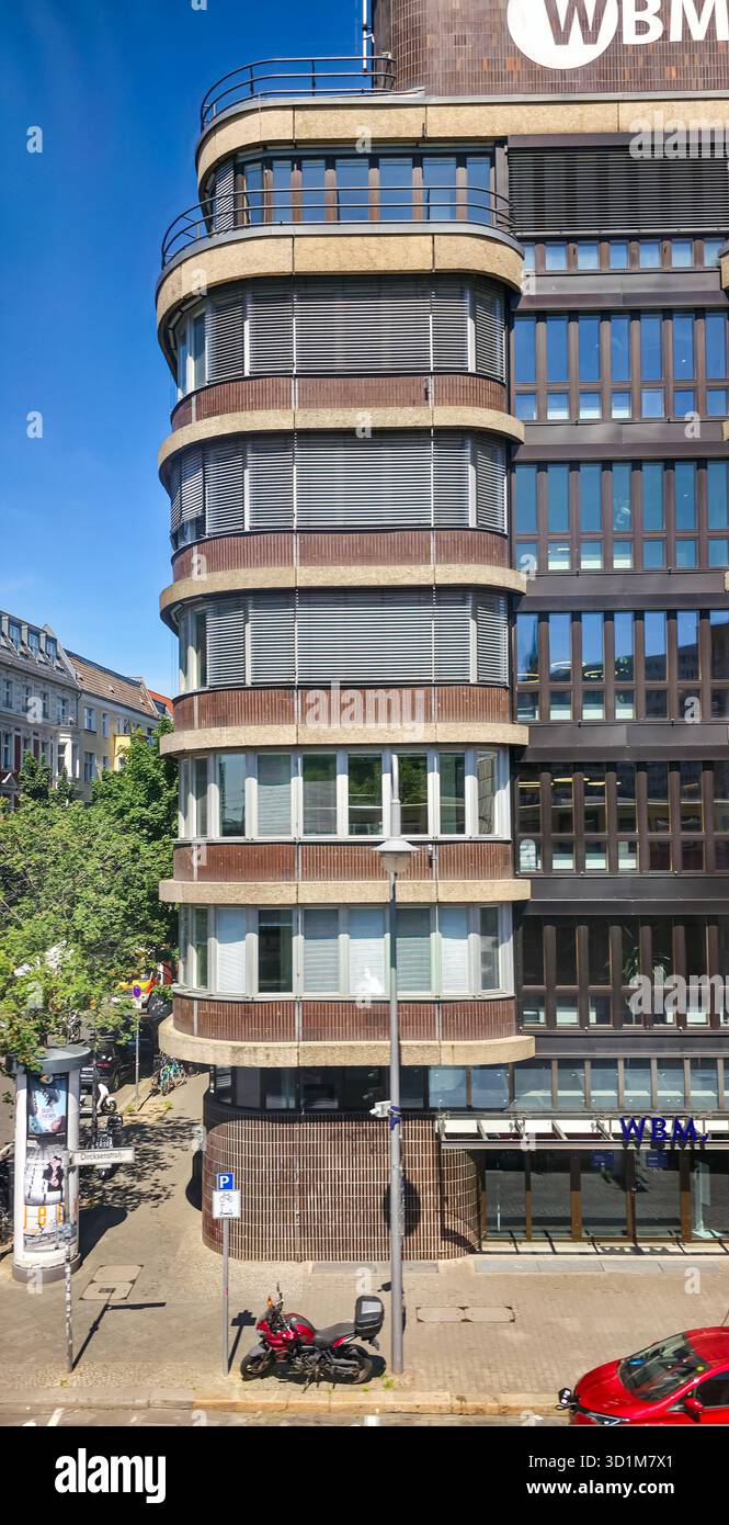 Berlin, Germany - May 13, 2025: Modern building features a unique curved facade and large windows showcasing contemporary architecture. - Smartphone Captured Stock Image