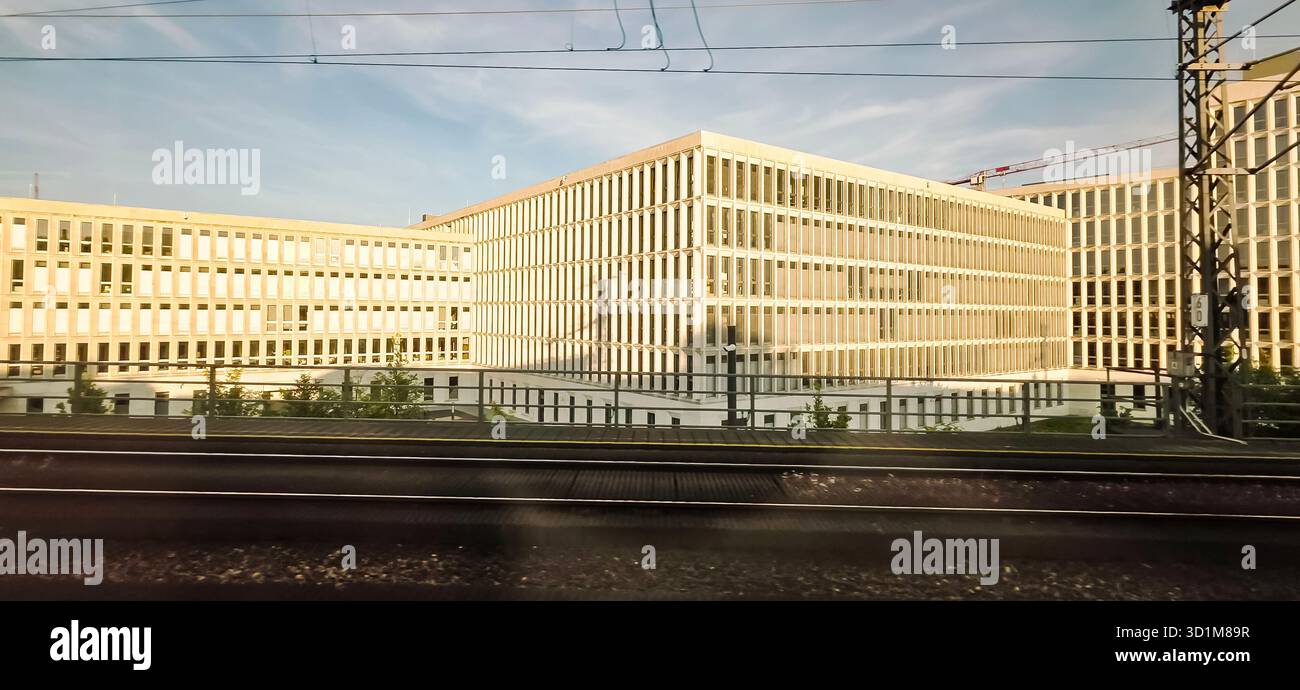 Berlin, Germany - June 13, 2025: Modern office buildings showcase geometric architecture beside railway tracks. - Smartphone Captured Stock Image