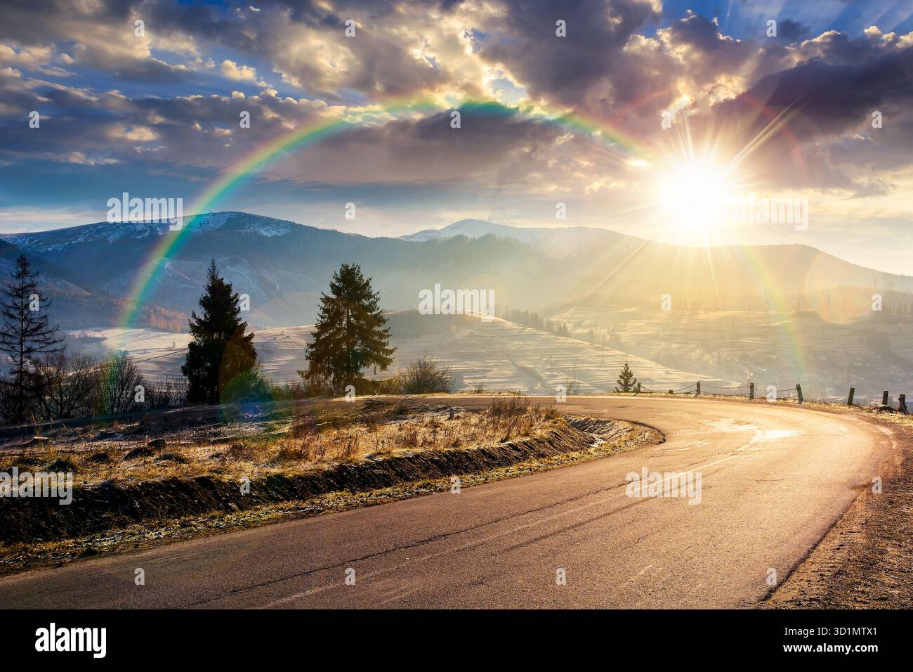 country road in mountains at sunset. beautiful countryside landscape in late autumn. fir trees on the roadside in evening light. scenic view of blue s Stock Photo