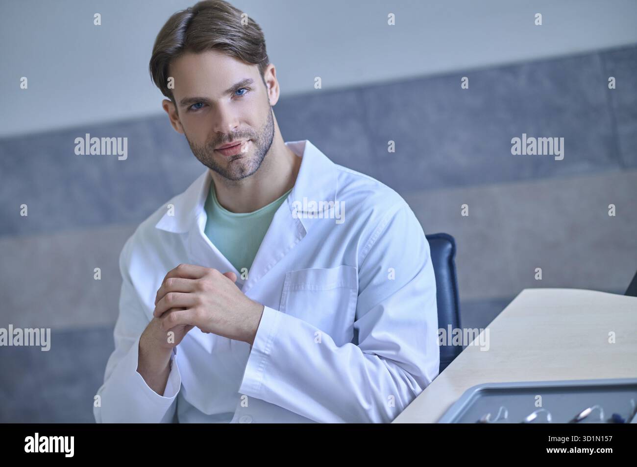 Thinking. Young doctor in a lab coat looking thoughtful Stock Photo