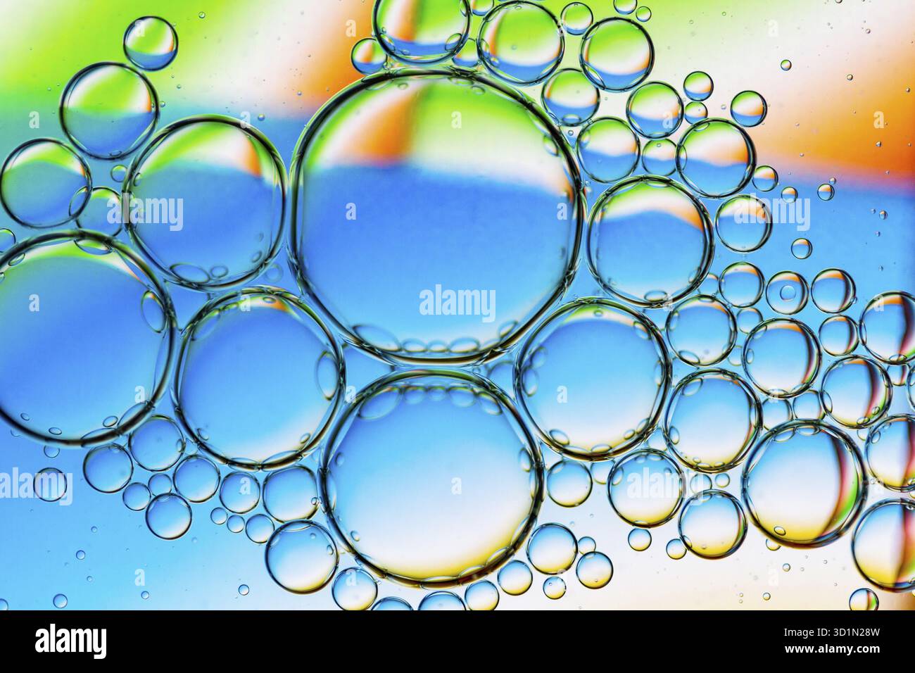 Abstract Background of Oil Bubbles on Water Surface cyan orange green colorful palette. Macro close-up shot Stock Photo