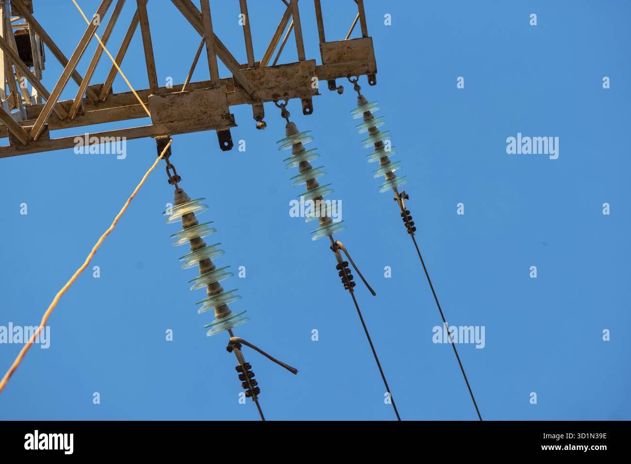 Power tower detail with three row od glass insulators and the wires in ...
