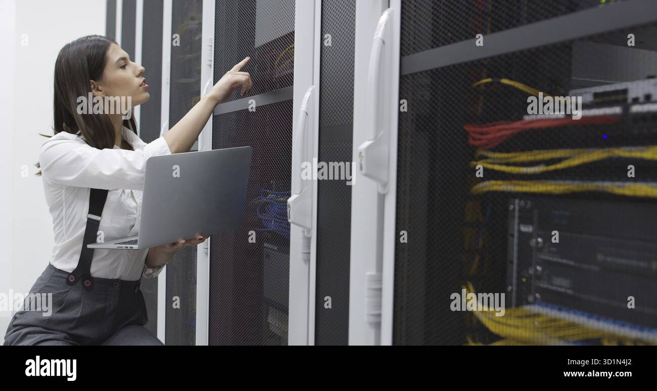 Technician performing maintenance tasks in a server room rack Stock Photo