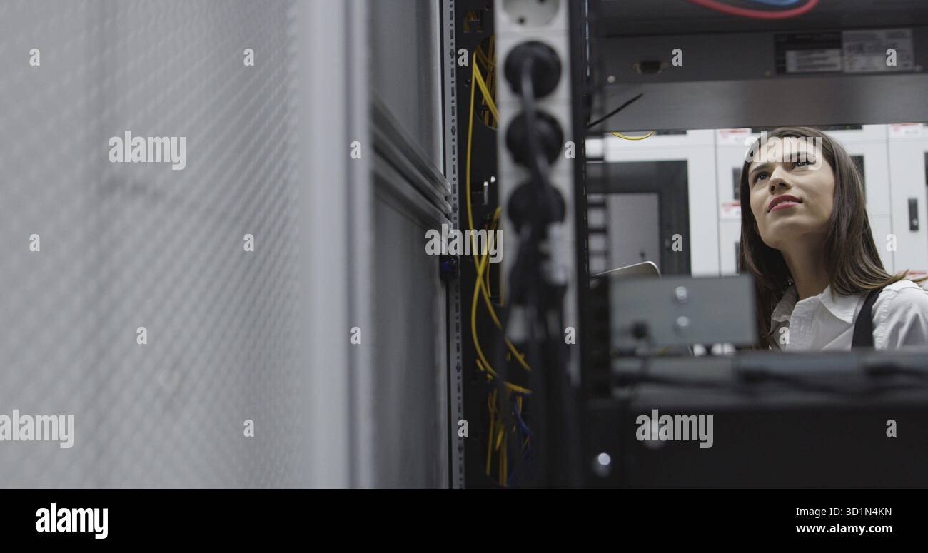 Technicians using laptop while analyzing server in server room Stock Photo