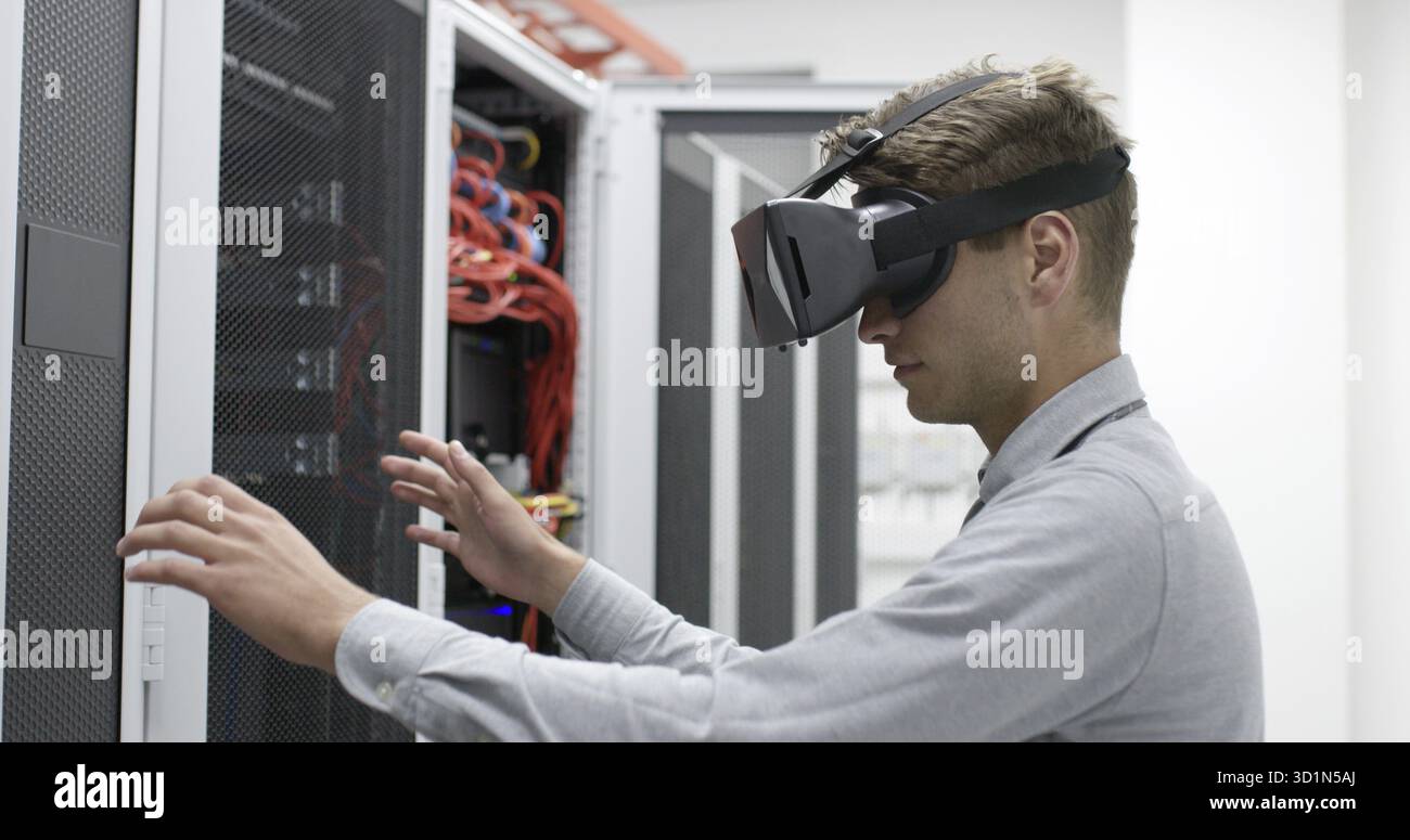 Young IT engeneer using virtual reality headset over server room background Stock Photo