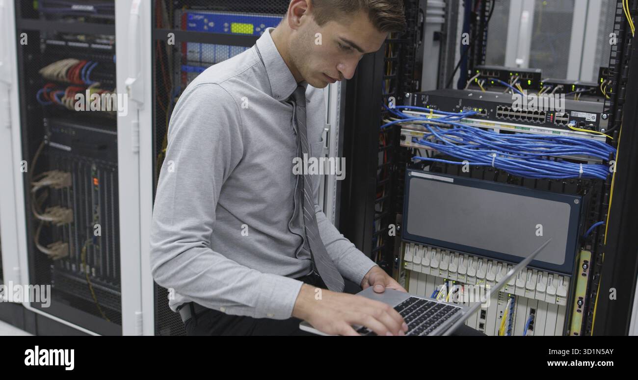 Technician performing maintenance tasks in a server room rack Stock Photo
