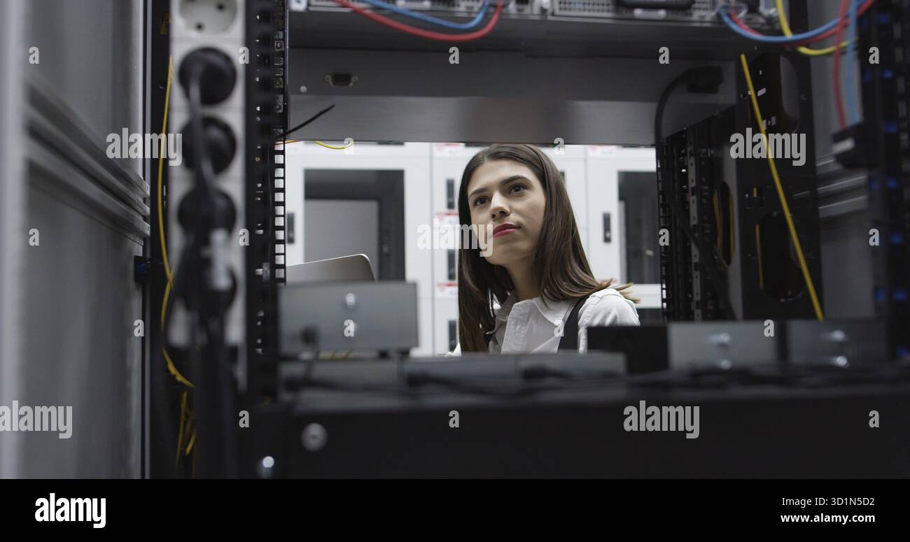 Technicians using laptop while analyzing server in server room Stock Photo