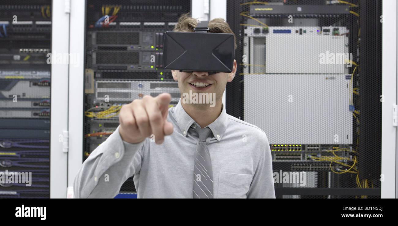 Young IT engeneer using virtual reality headset over server room background Stock Photo