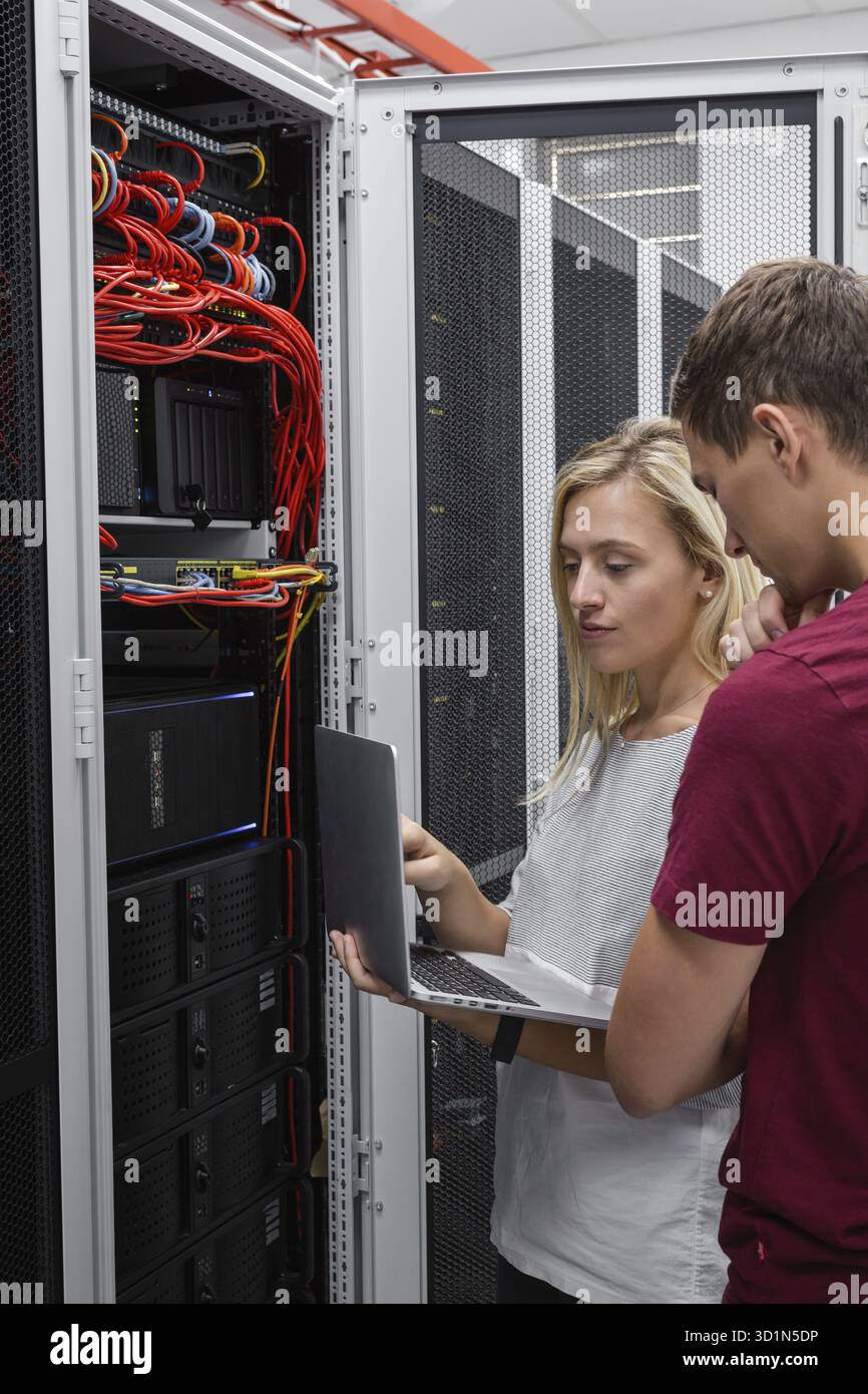Two IT Engineers in Data Center, Server Room Stock Photo