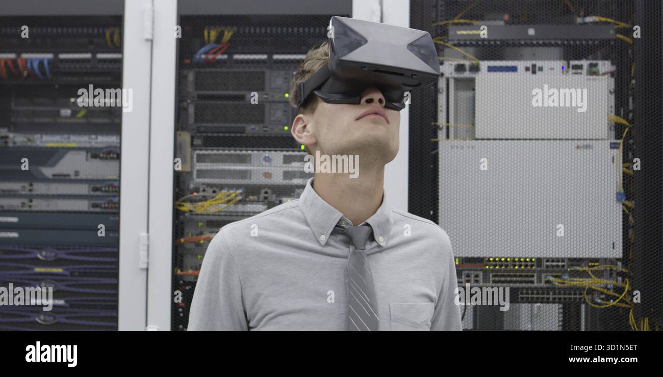 Young IT engeneer using virtual reality headset over server room background Stock Photo