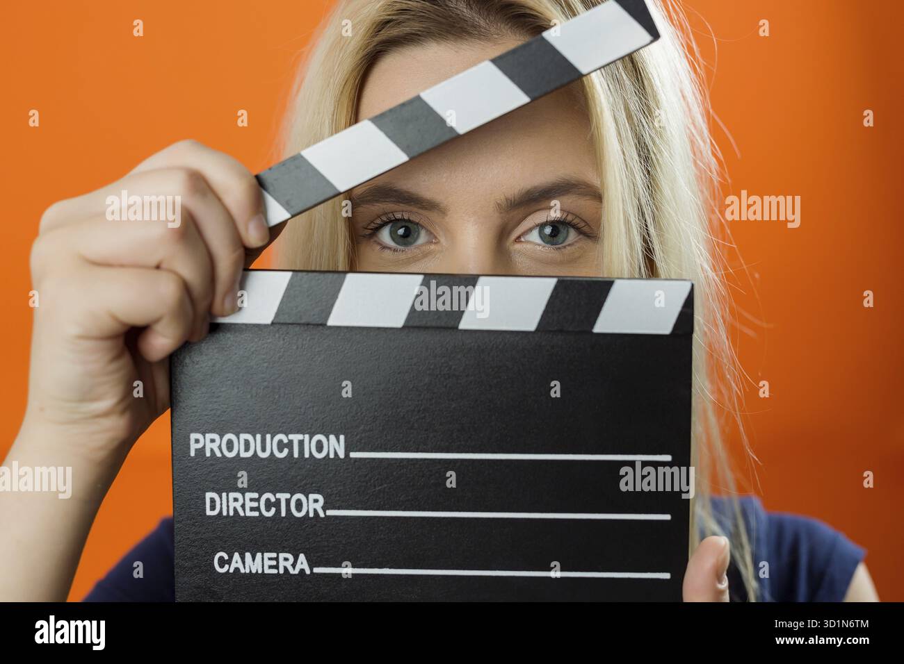 Young woman in action, holding clapperboard. Cinema concept Stock Photo