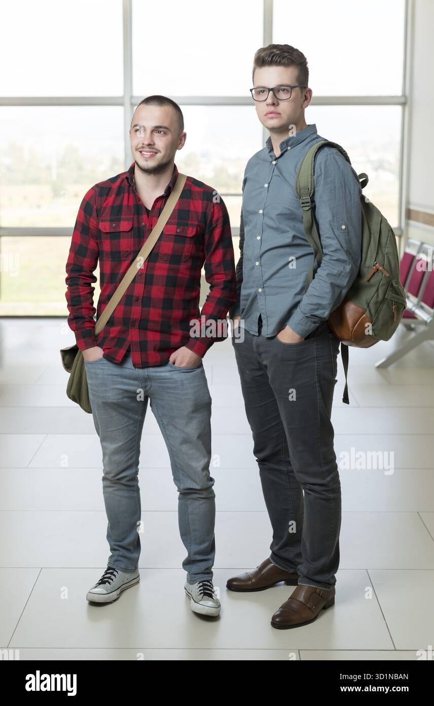 Smiling handsome students posing in a corridor Stock Photo
