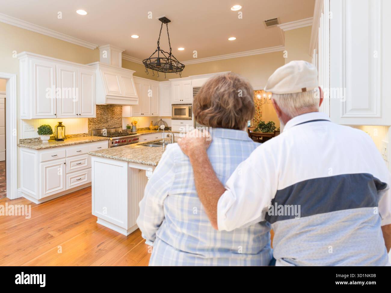 Senior Couple Looking Over Beautiful Custom Kitchen Stock Photo