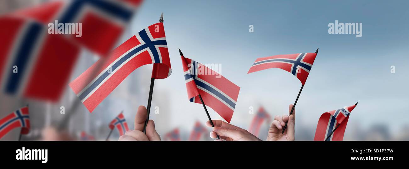 Norway flags in their hands on a blurred urban background. The photo ...