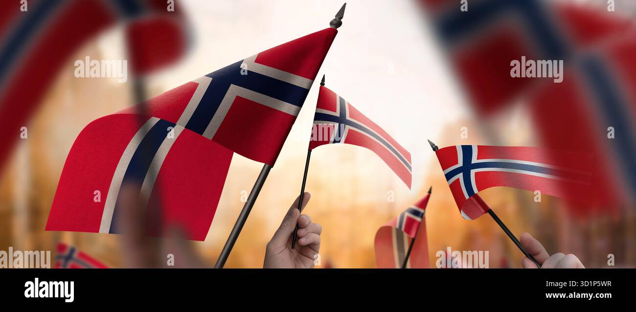 Norway flags in their hands on a blurred urban background. The photo ...