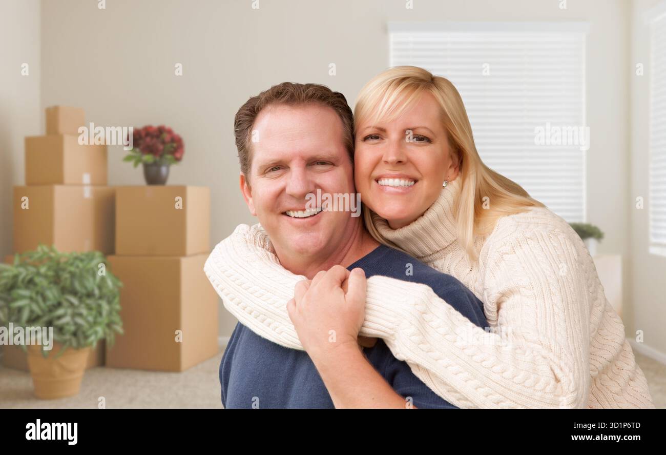 Young Couple in Empty Room with Packed Boxes Stock Photo