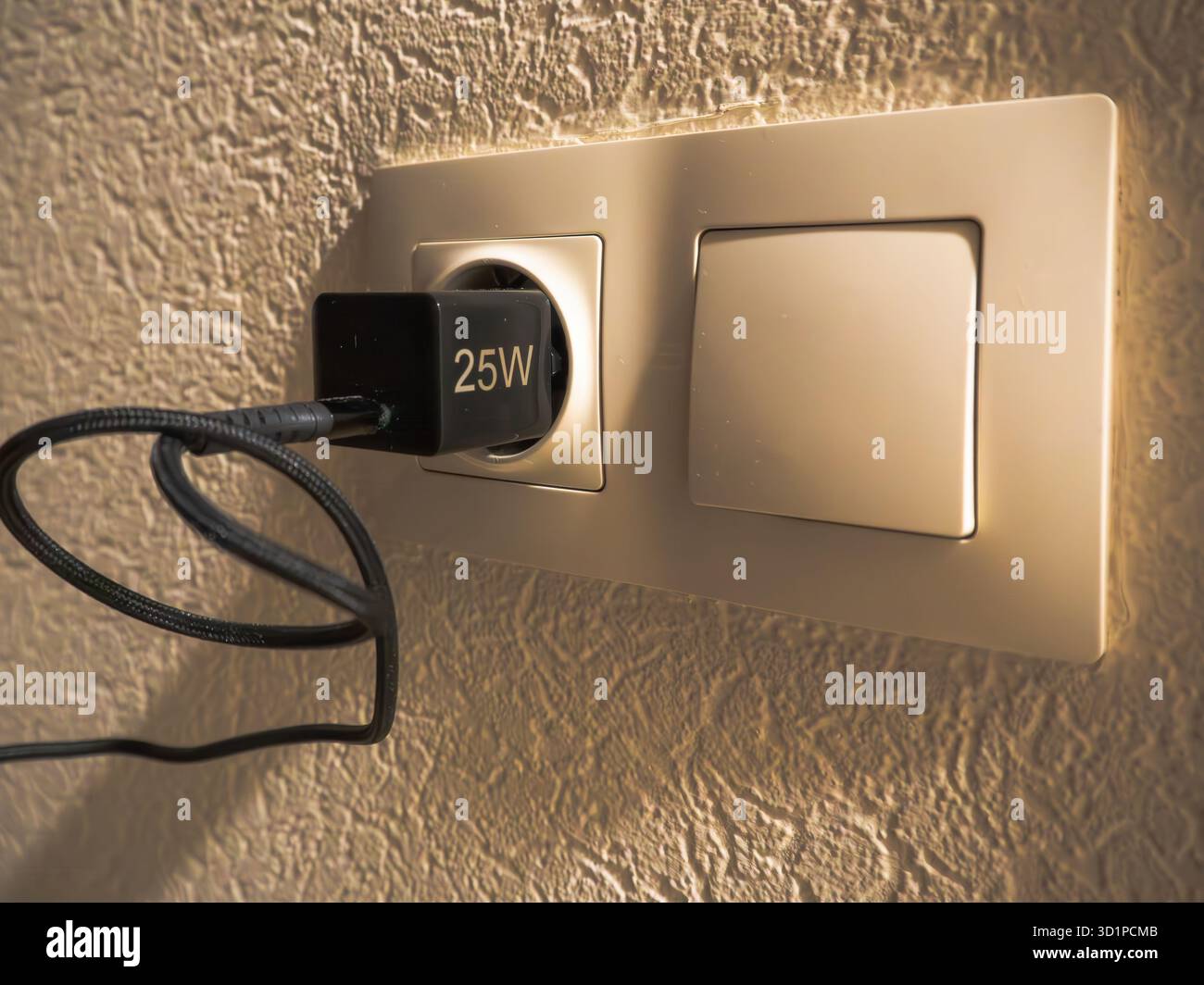Wall electrical socket and light switch with 25W charger plugged in ...