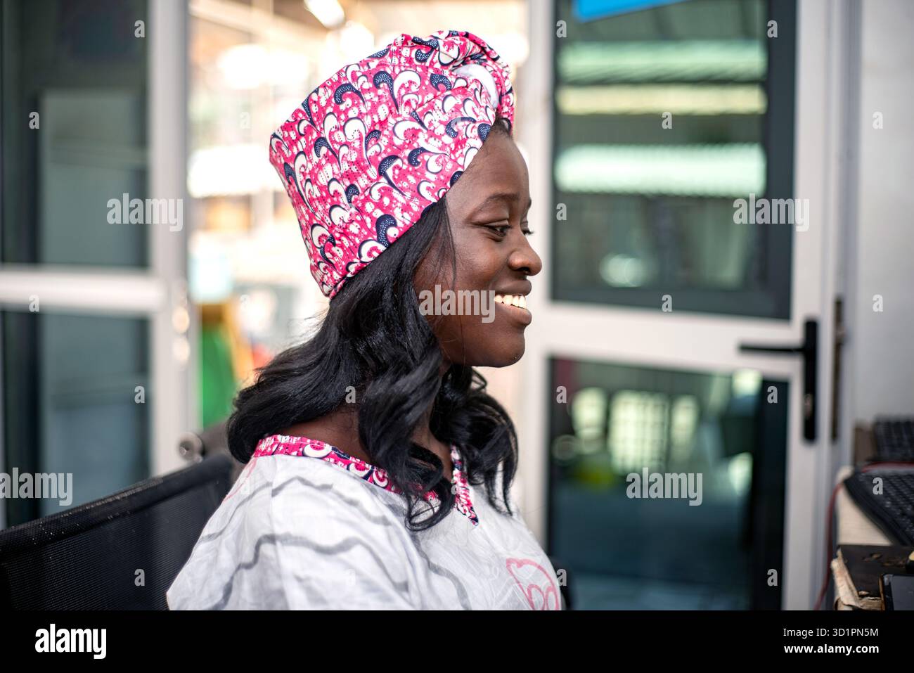 a beautiful african businesswoman in traditional outfit sitting at the ...