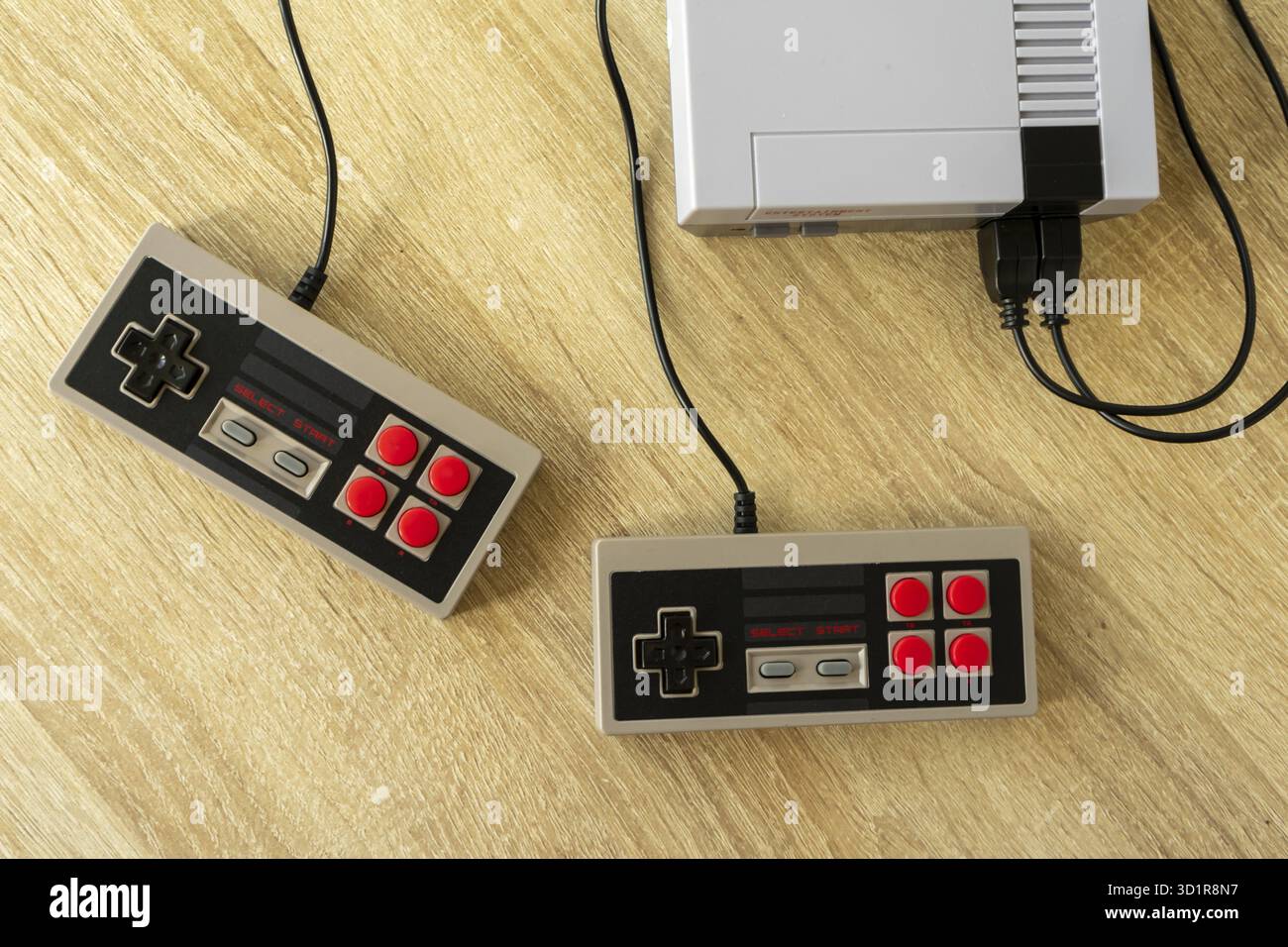 Retro gaming console with classic gamepad controller on a wooden table Stock Photo