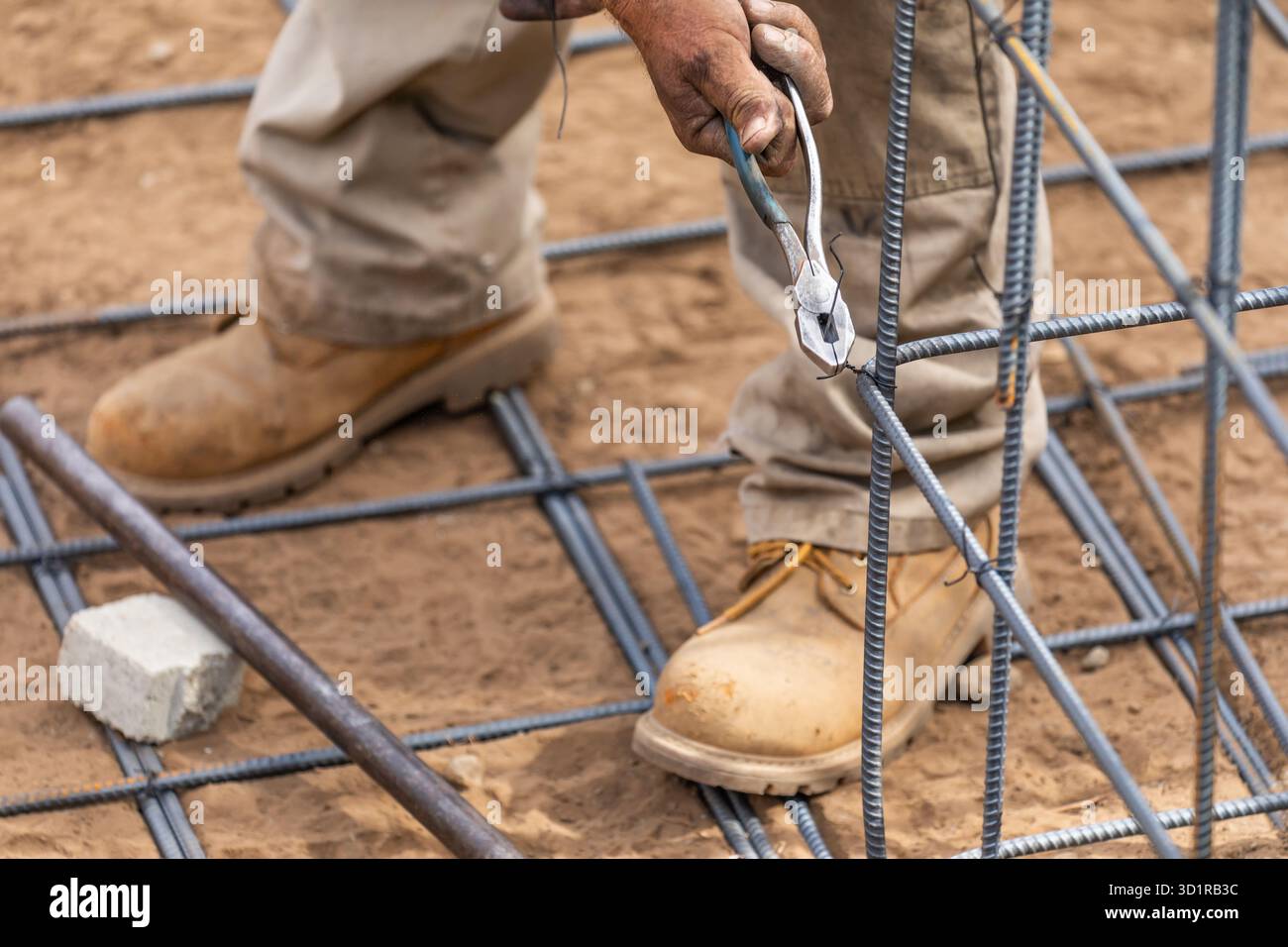 Worker Securing Steel Rebar Framing With Wire Plier Cutter Tool At ...