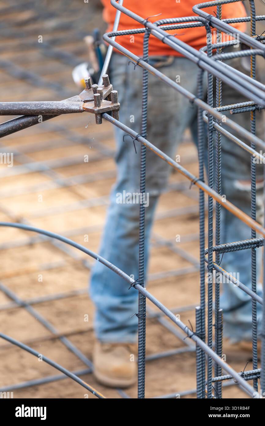 Worker Using Tools To Bend Steel Rebar At Construction Site Stock Photo
