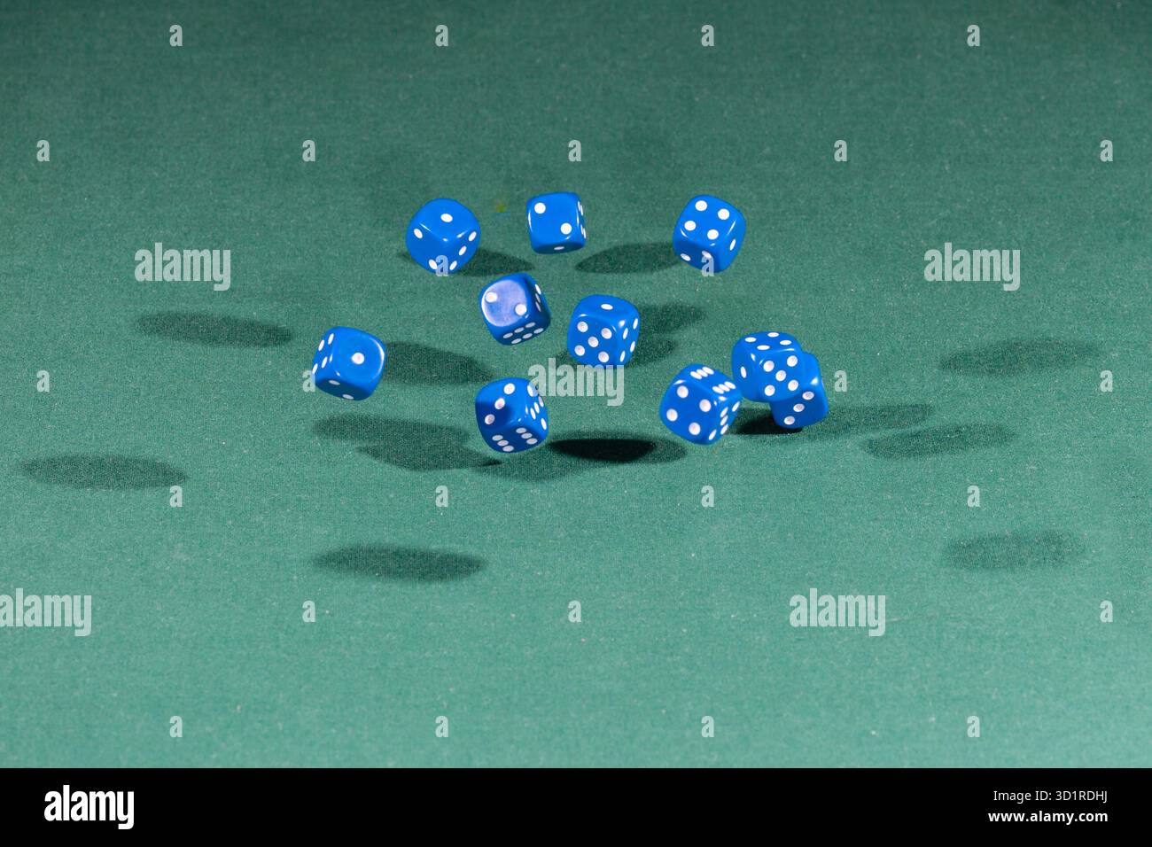 Ten blue dices falling on a green table Stock Photo