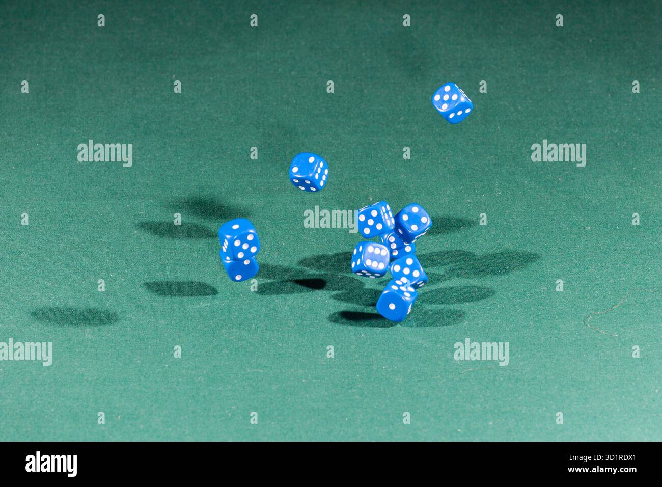 Ten blue dices falling on a green table Stock Photo