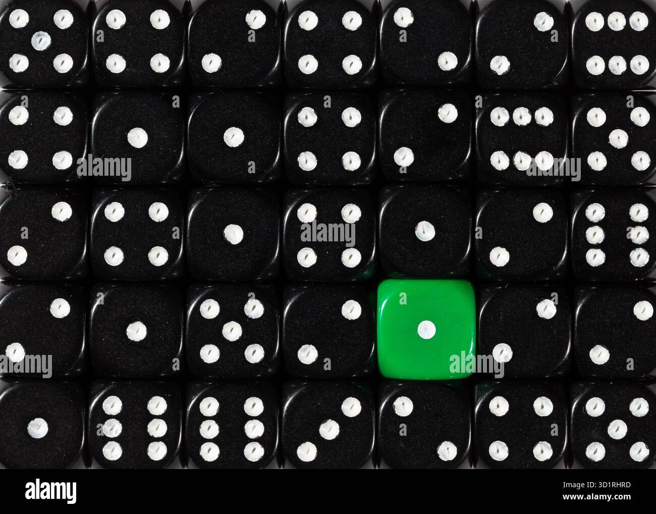 Background of random ordered black dices with one green cube Stock Photo