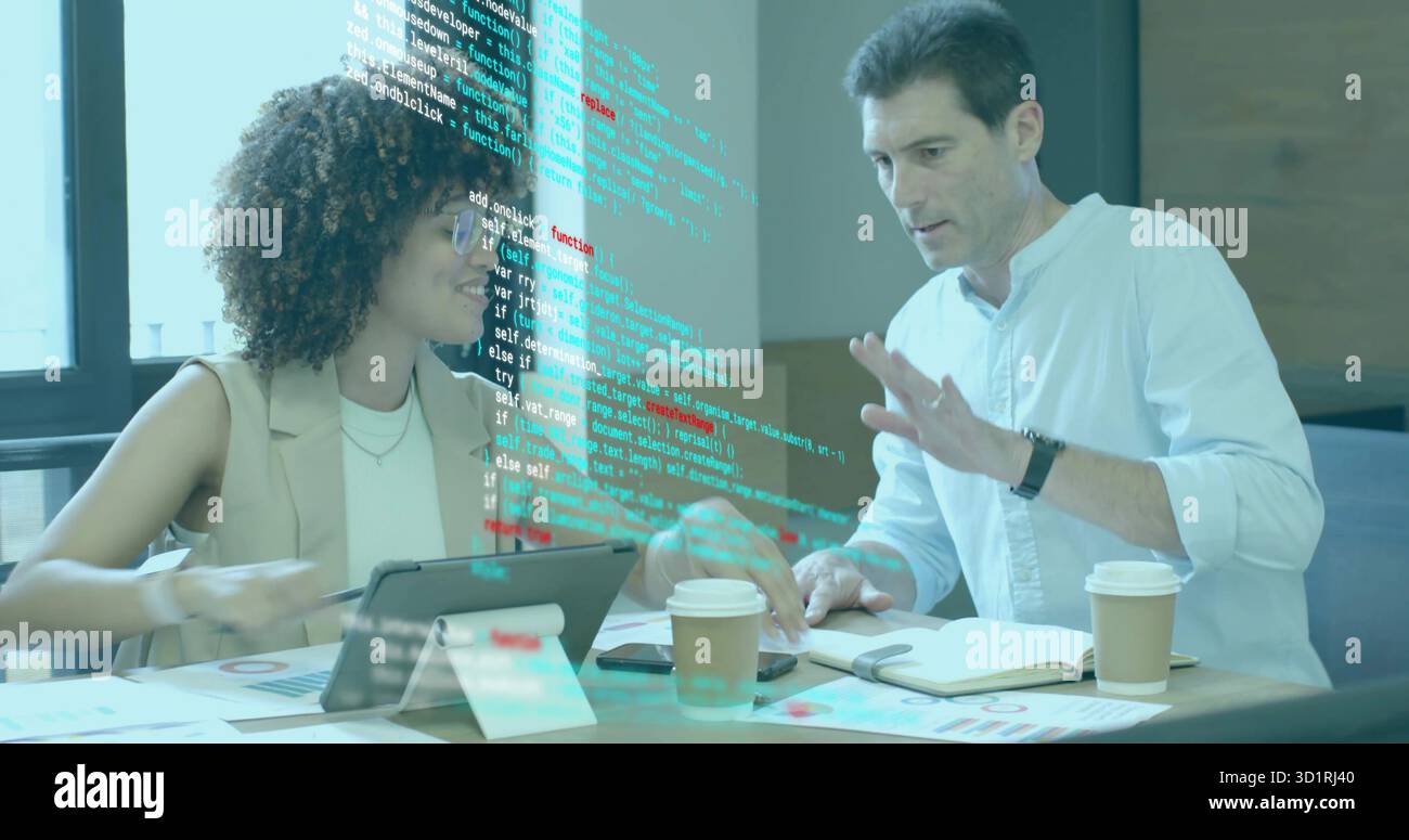 Reviewing software two software professionals collaborating in office, with tablet and charts Stock Photo