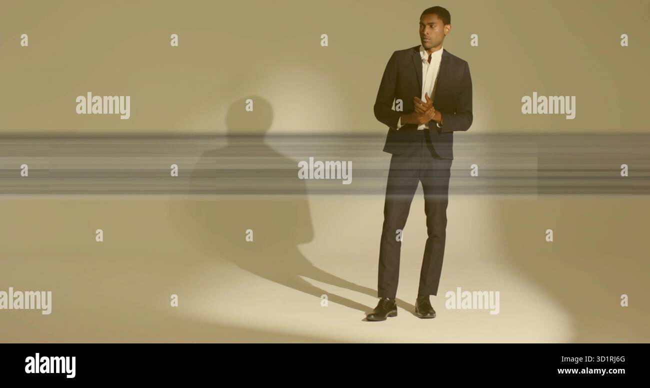 Standing black man in studio wearing tailored dark suit with white shirt, dress shoes, copy space Stock Photo