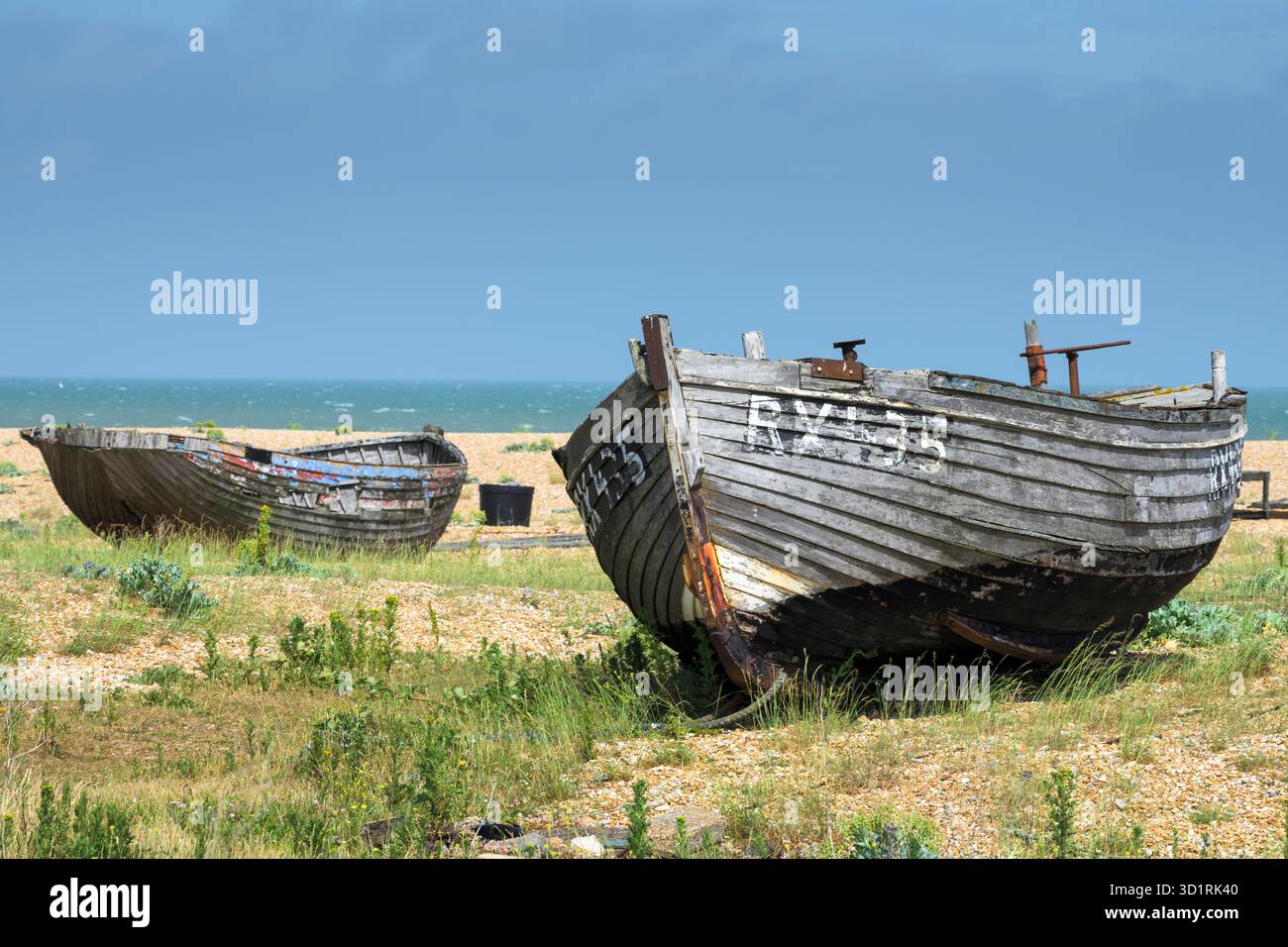 Abandoned fishing boats on a shingle beach in Dungeness, Kent, England ...