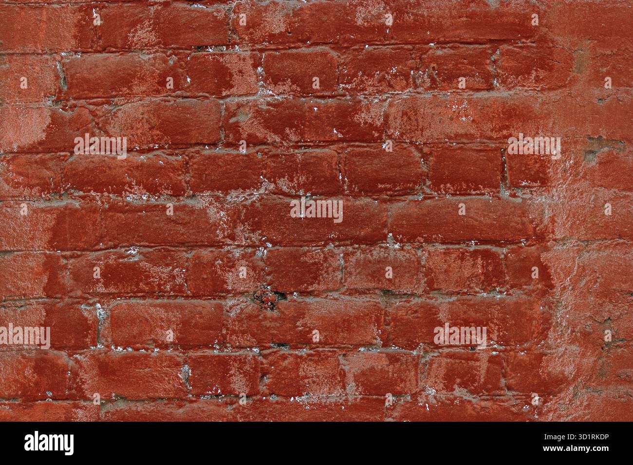 Old red brick wall painted in two different tones Stock Photo