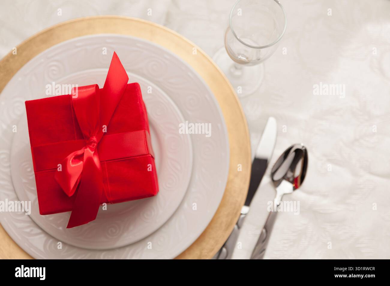 Christmas Gift with Place Setting at Table Stock Photo