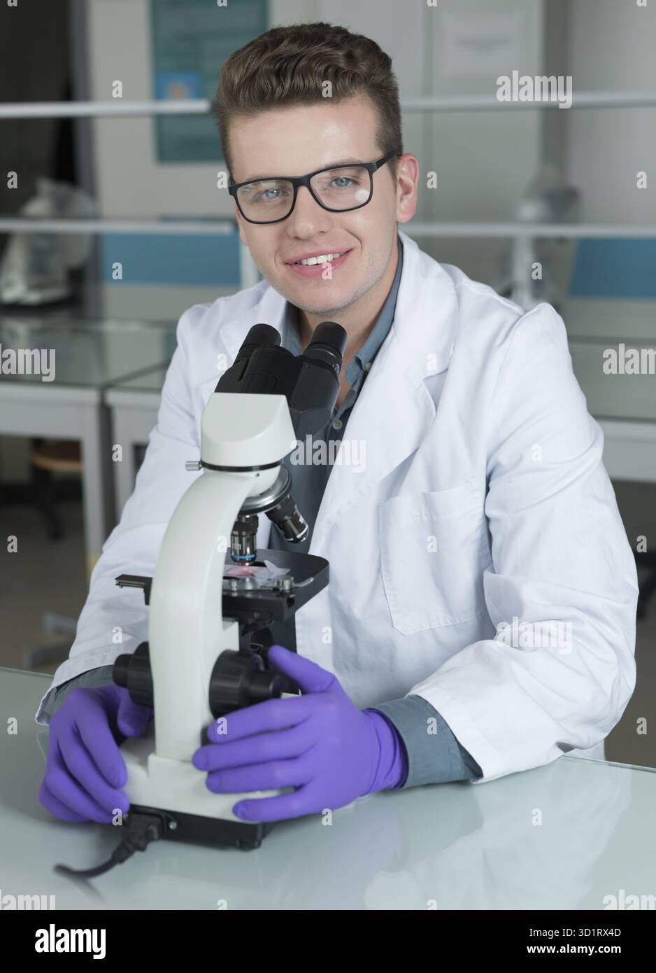 Scientist looking through a microscope in a laboratory Stock Photo