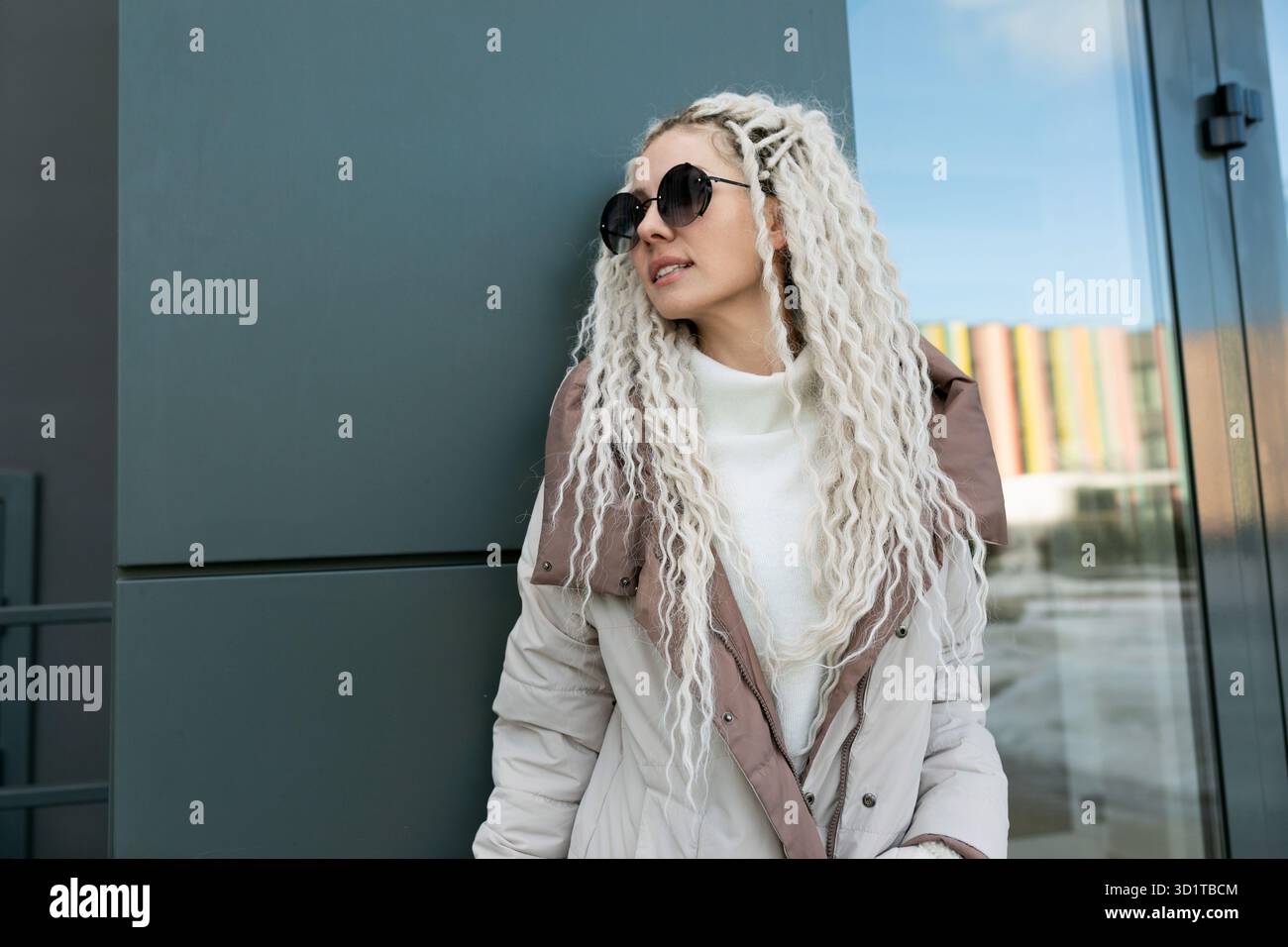 Woman With White Dreadlocks Leaning Against a Wall Stock Photo