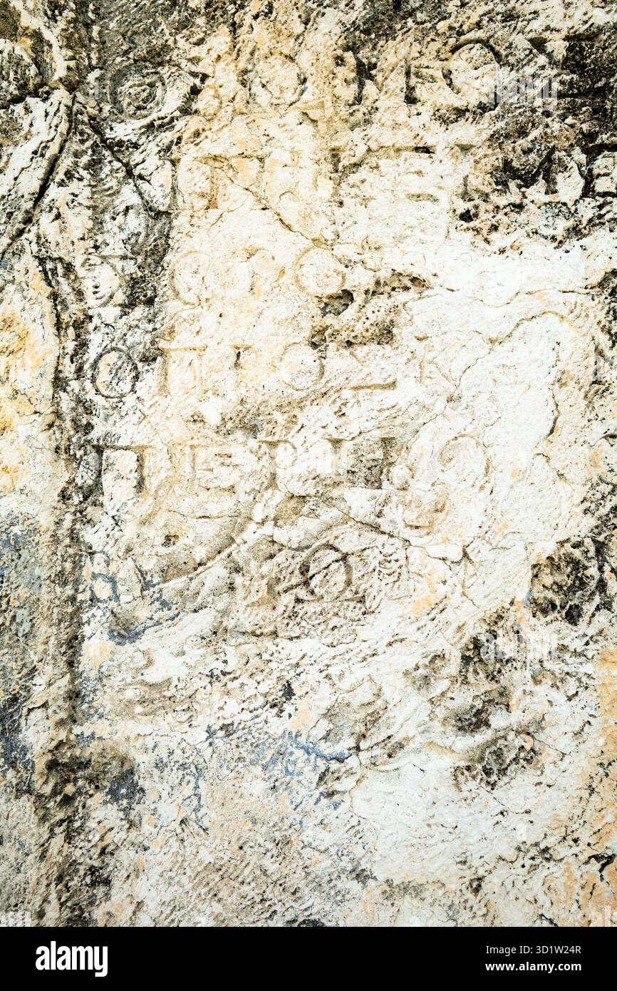 ancient stone wall texture with ancient script and slphabets. texture ...