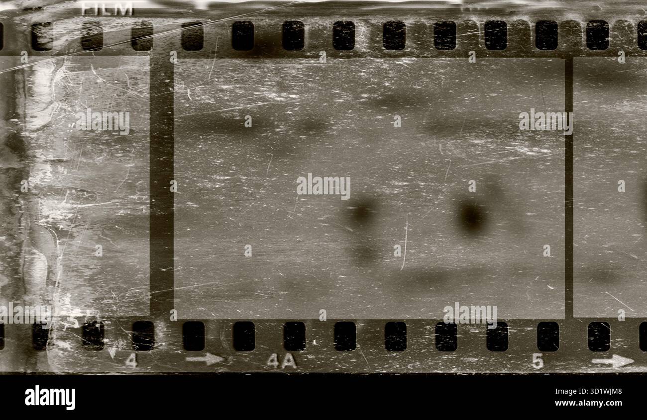 Grunge vintage film negative strip on dirty worn and weathered scratched background for background and overlay Stock Photo