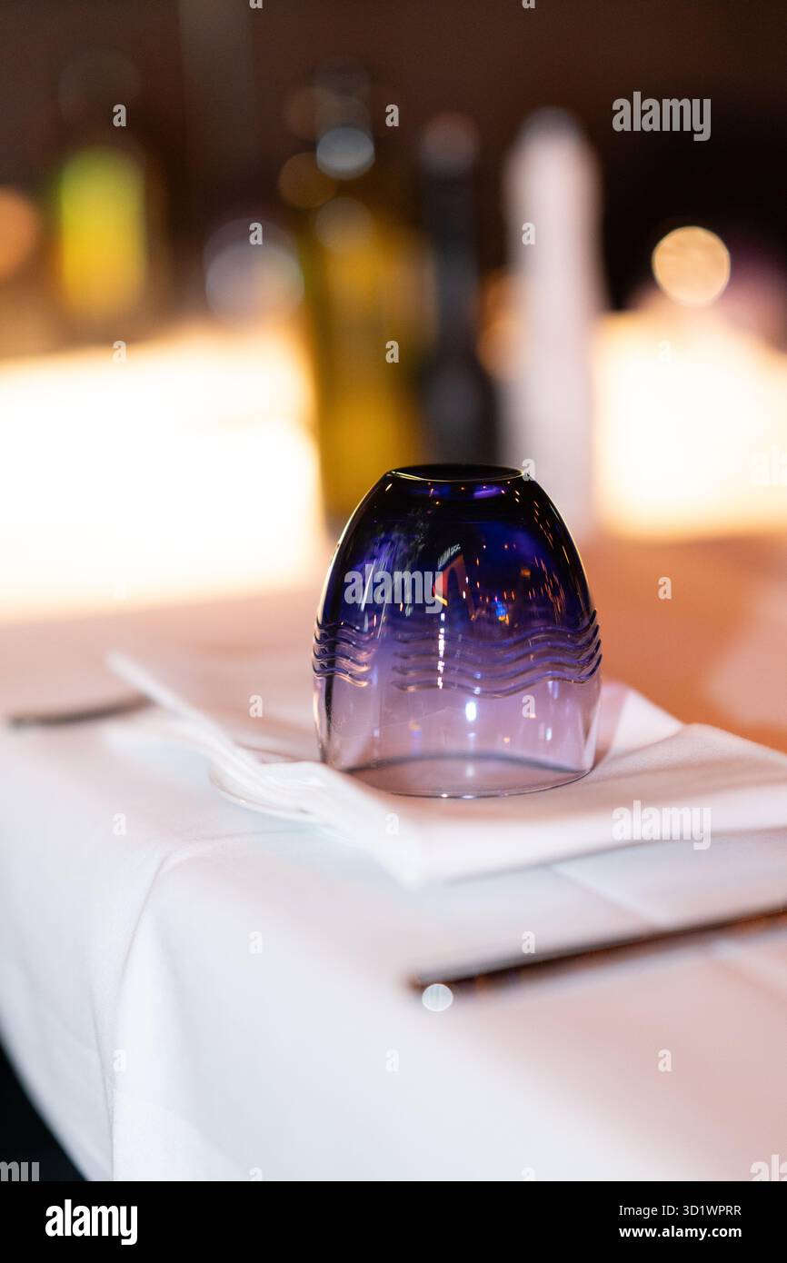 Blue Glass Upside Down on White Tablecloth Stock Photo