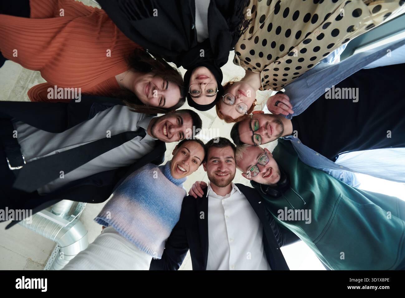 A diverse group of business professionals standing together in a ...