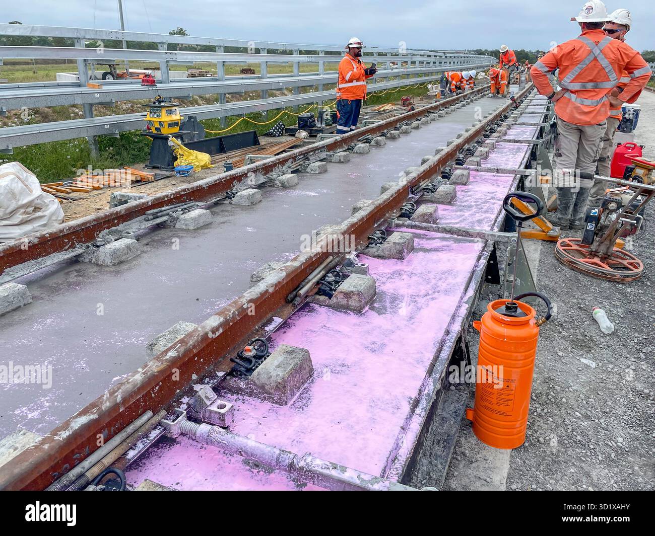 Install lay rail track rails on transport project in Western Sydney, construction workers in PPE and hi viz vests, building site, Australia - Smartphone Captured Stock Image