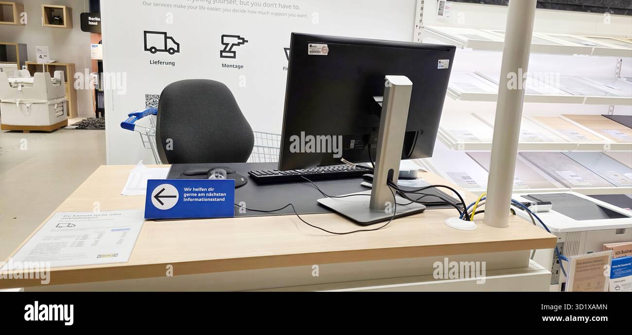 Berlin, Germany - May 05, 2025: Modern checkout desk features computer, chair, and directional signage in retail store. - Smartphone Captured Stock Image